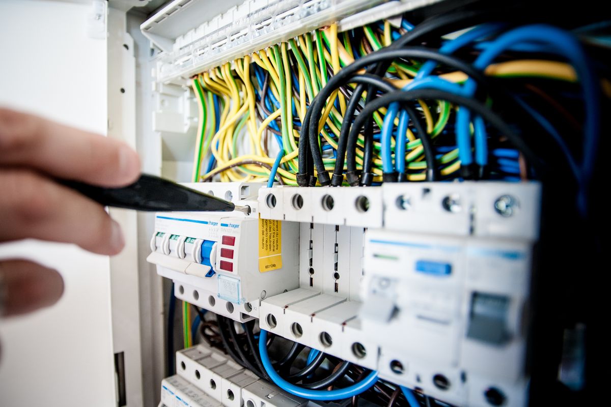 Services Électricien travaillant sur un tableau électrique – Blue Vert