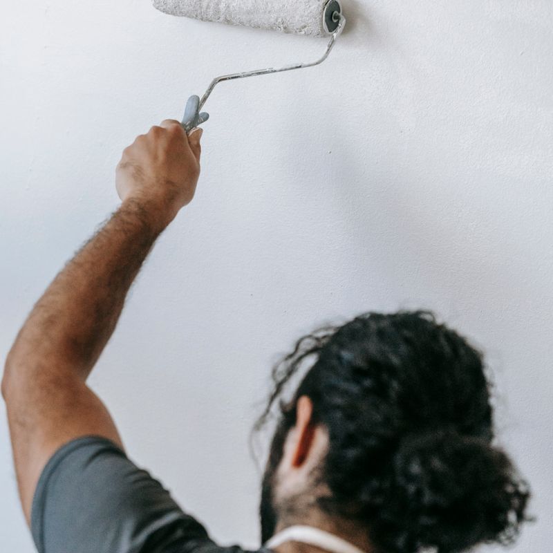 Peintre appliquant de la peinture au rouleau sur un mur – Blue Vert