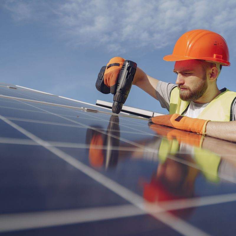 Installateur fixant des panneaux solaires sur un toit – Blue Vert