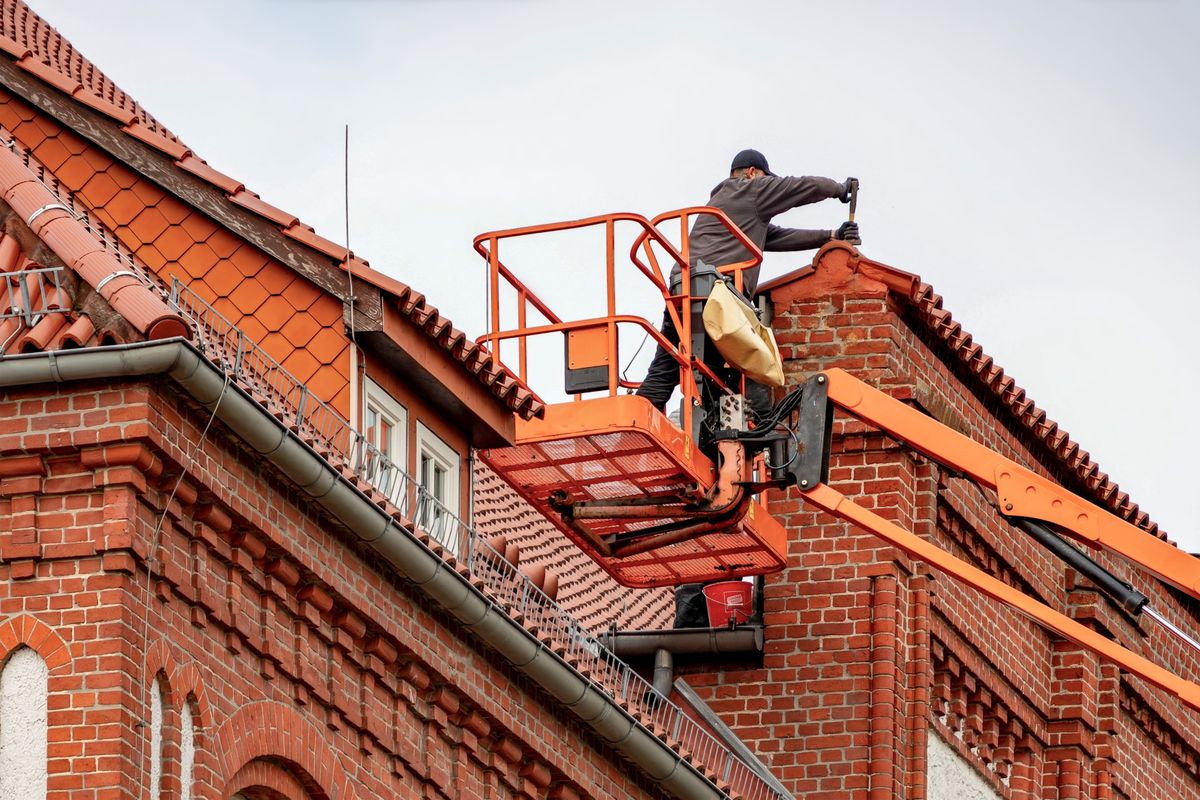 Services Couvreur en nacelle travaillant sur une toiture en tuiles – Blue Vert