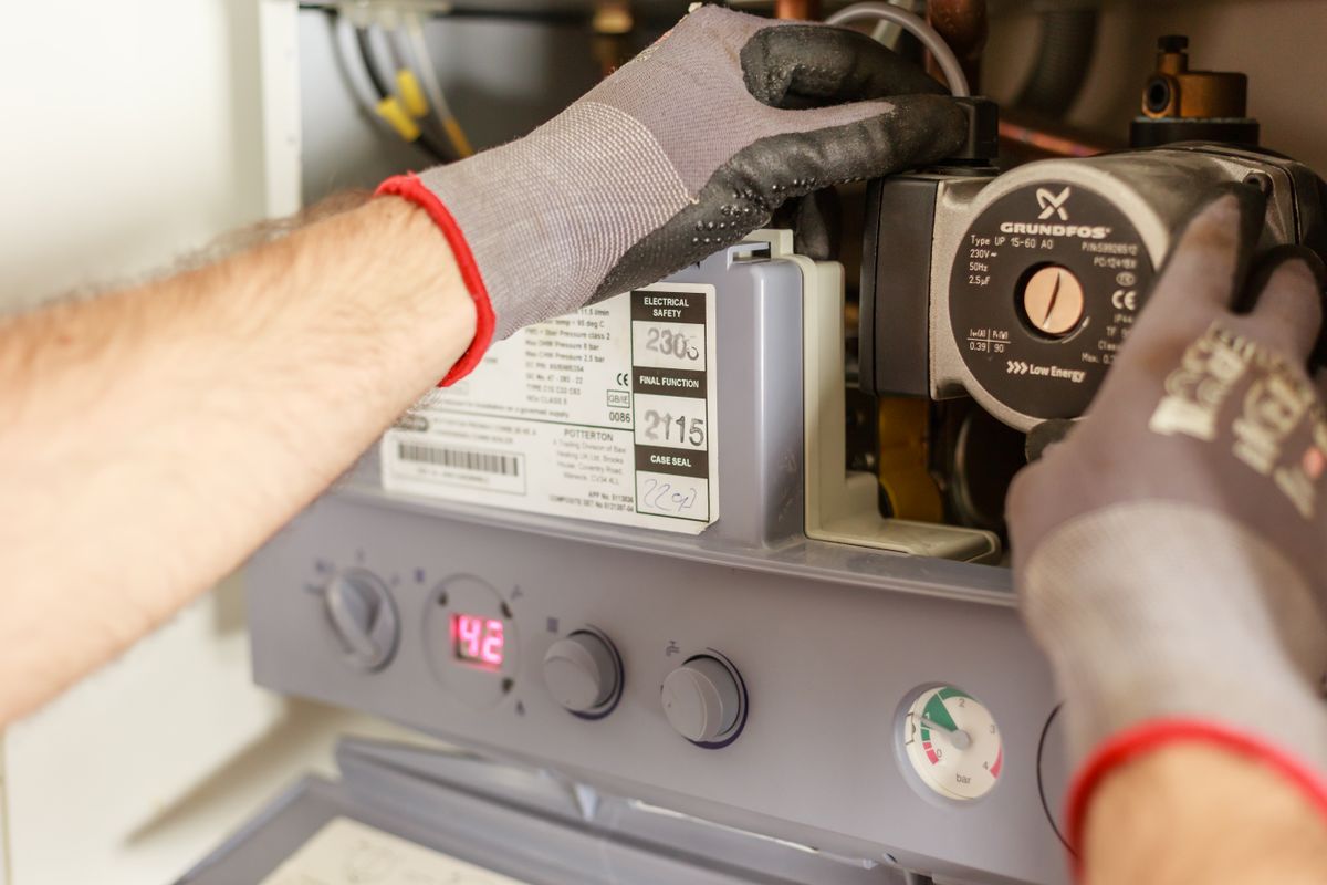 Services Technicien réglant une chaudière – plomberie et chauffage Blue Vert